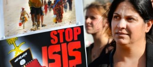A holds a sign calling to "Stop ISIS" (ISIS fir Islamic State) on August 13, 2014 as she takes part in a demonstration called by Kurds in support of the Yezidis and the Christians in Iraq, in Arnhem, The Netherlands. Thousands of civilians who escaped a jihadist siege streamed into Kurdish-controlled northern Iraq on August 13 as the West boosted efforts to assist people still trapped and arm Kurds battling to break the siege. AFP PHOTO / ANP / PIROSCHKA VAN DE WOUW ** netherlands out **